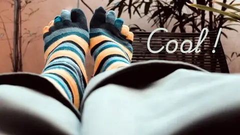 Personne allongée avec des chaussettes à doigts rayées couleurs aux pieds