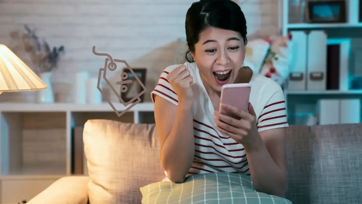 Jeune femme contente des remises obtenues lors de ses achats en ligne