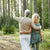 Un couple âgé marchant dans les bois, profitant d'une sortie ensemble et montrant de l'affection.